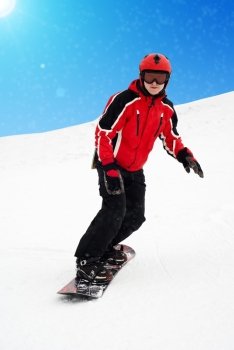 Man on snowboard skiin down on mountain. It is snowing