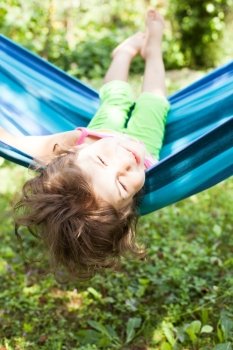 Little girl in a hammock enjoys the summer