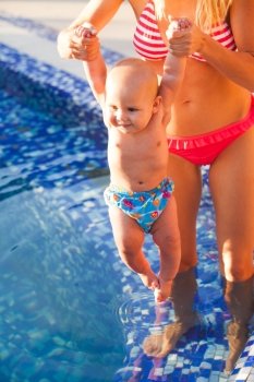Pretty young mom with baby at the swimming pool. Mom and baby rest