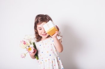 Little girl with tulips and box with present for mom