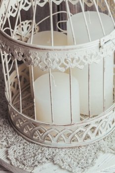 Three white Christmas candles inside bird cage. Shabby chic home decor. The Christmas candles