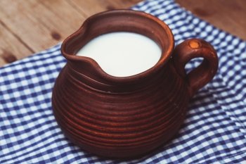 Clay jug  full of milk in a rustic style. Healthy drink