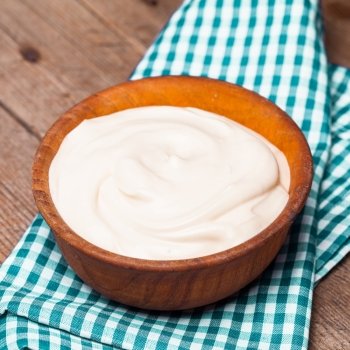 Sour cream in a wooden bowl. Farm organic product. The sour cream