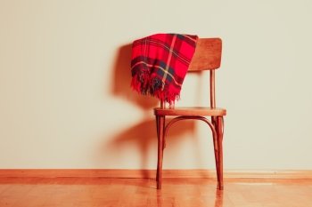Old chair with carelessly abandoned blanket on it. The vintage chair
