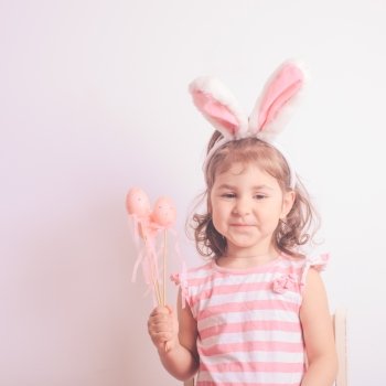 Girl with little pink eggs for the Easter hunting. Pink decorative eggs