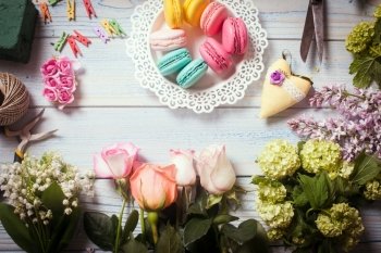Sweet macarons and flowers - preparation of present. Sweet present
