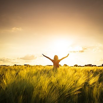 Teenage girl enjoy with sunshine in wheat field. Girl on sunset