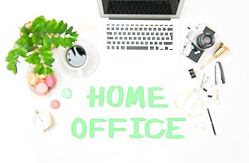 Workplace with laptop and office supplies. Blurred background. Flat lay out of focus. Sample text HOME OFFICE
