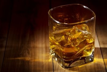 glass of whiskey on wooden table