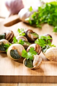 escargots with parsley on wooden table