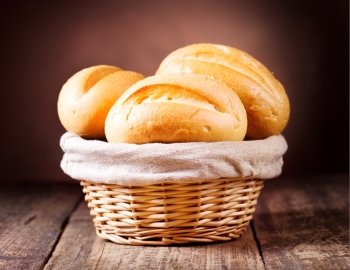 bread in wicker basket on wooden background