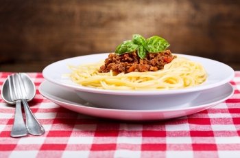 plate of spaghetti bolognese with green basil