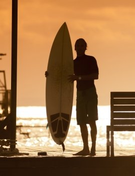 Surfer  with a surfboard at Sunset Tme, Bali, Indonesiareleased