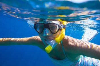 Young women is snorkeling in the tropical water