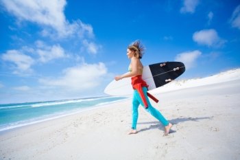 Surfer girl holding a surfboard at the beah