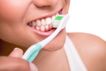 Smiling young woman with healthy teeth holding a tooth brush