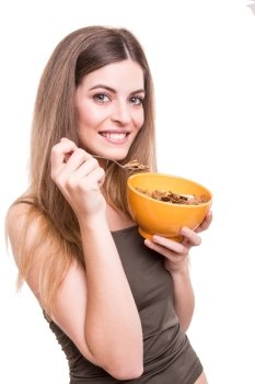 Beautiful young woman eating cereals over white background