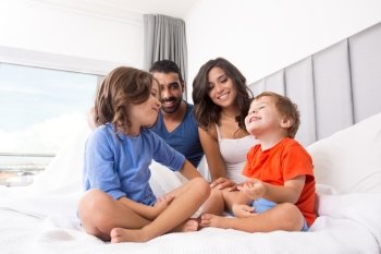 Happy family enjoying the morning in bed