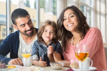 Child having breakfast with her mother and father