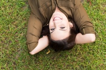 Smiling woman lying and relaxing in grass