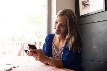 Casual woman using smartphone at coffee shop