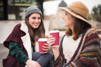 Couple of friends with hot drink on winter