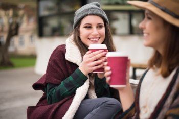 Couple of friends with hot drink on winter
