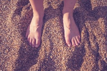 The feet of a young woman on the beach