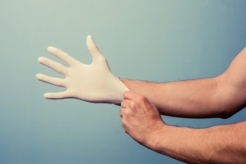 Man putting on a latex glove