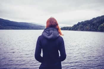 Young woman admiring the stillness of a lake
