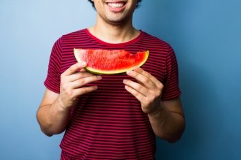 Young man is eating watermelon 