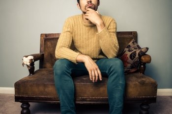 THoughtful young man sitting on a sofa