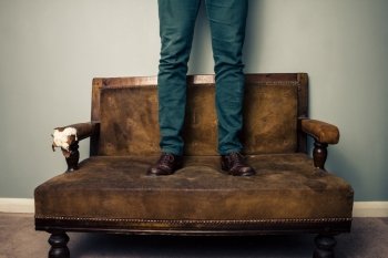 Man standing on sofa
