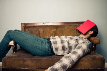 Man sleeping on sofa with book on his face
