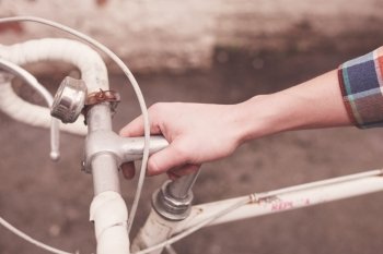 Young woman’s hand holding the steer of a bicycle