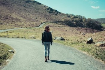 Young woman is walking along a path in the mountains
