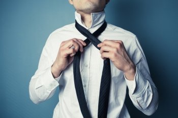 A young man is showing how to tie a necktie