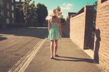 A young woman is walking in the street on a sunny day
