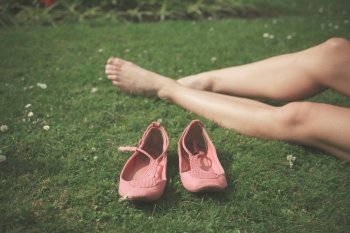 The bare legs of a young woman as she is relaxing on the grass in a park