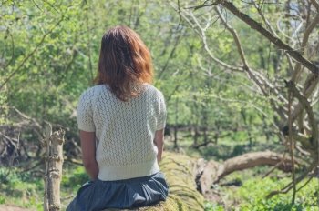 A young woman is exploring a forest on a sunny day