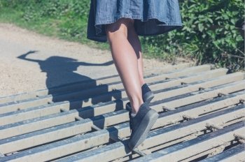 A young woman is tripping on a cattle grid in the countryside