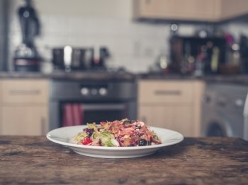 A plate with salad on a table in a kitchen