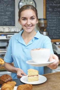 Waitress In Cafe Serving Customer With Coffee