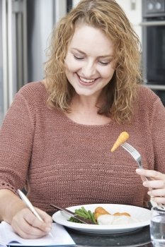 Woman On Diet Writing Details In Food Journal