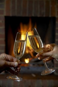 Couple With Glass Of Champagne Relaxing By Fire