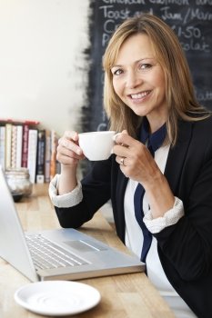 Businesswoman Using Laptop In Cafe