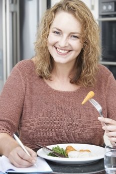 Woman On Diet Writing Details In Food Journal
