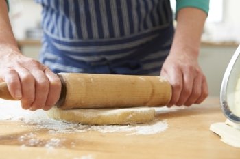Close Up Of Hands Using Rolling Pin To Roll Out Pastry
