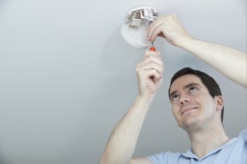 Man Installing Smoke Or Carbon Monoxide Detector