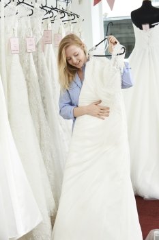 Bride Choosing Dress In Bridal Boutique